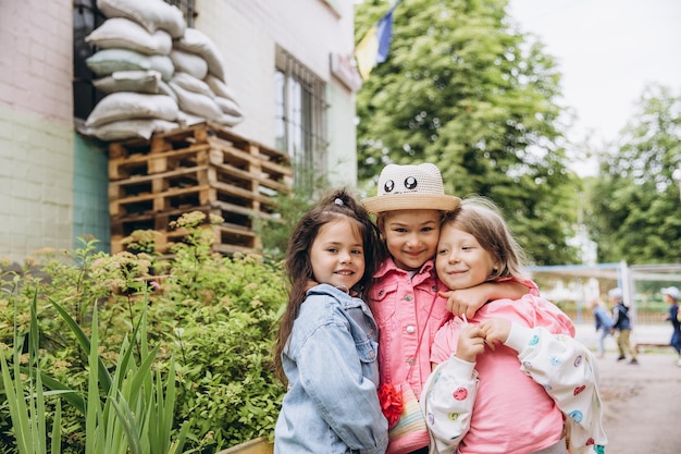 070722 Irpin Ukraine Kindergarten children play in the yard of the building which has a lining and a protected sandbag to protect against the blast wave Weekdays of Ukrainian children