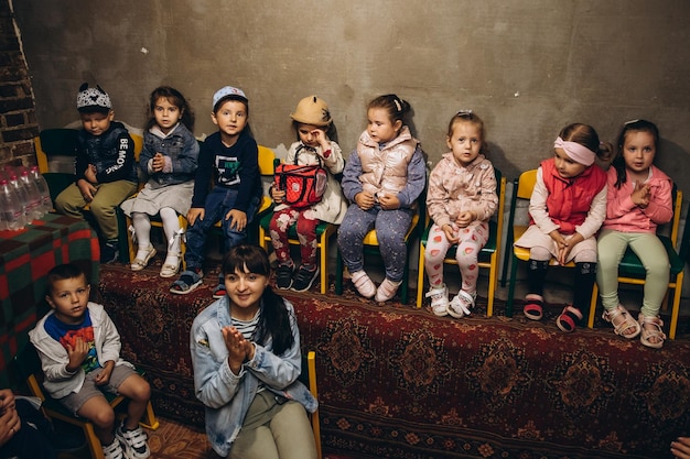 070722 Irpin ウクライナの小さな子供たちとその保護者は、空襲の際に避難所として使用された地下室に避難しています