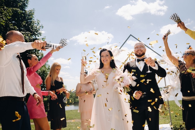 08.07.2021. Nesvizh.Belarus. A happy wedding couple with glasses of wine passes along the guests after the wedding ceremony