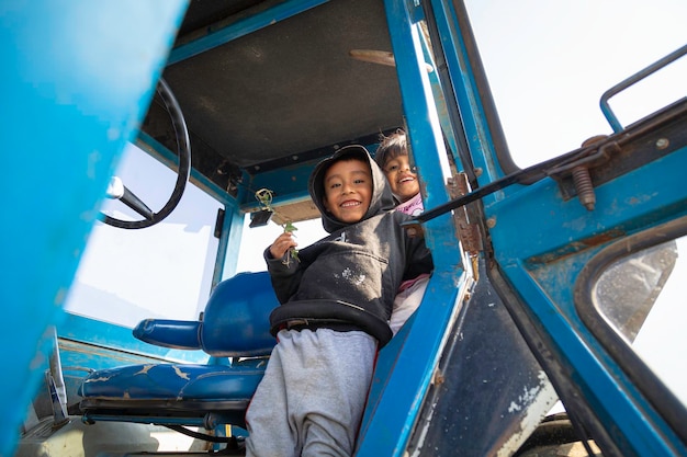 1 Fun in the countryside children laughing and playing on a tractor in the midst of nature