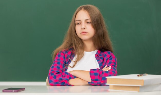 1 september jeugdkind klaar om verdrietig tienermeisje te studeren dat naar de telefoon kijkt terug naar school