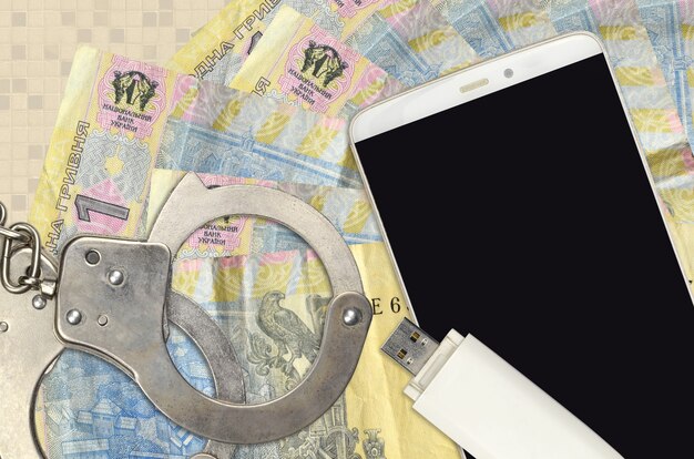 1 Ukrainian hryvnia bills and smartphone with police handcuffs