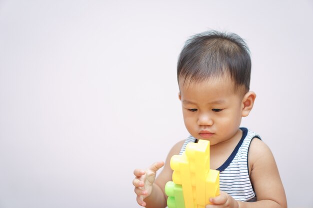 A 1 year and 4 months Asian baby playing plastic blocks