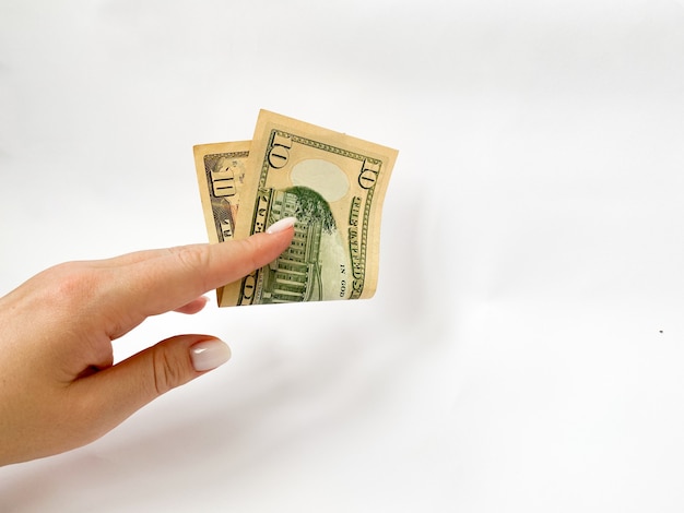 10 dollari in mano primo piano su uno sfondo bianco isolato una banconota tendinea