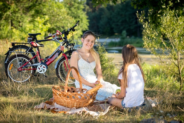 10-jarig meisje dat picknickt bij de rivier met jonge moeder