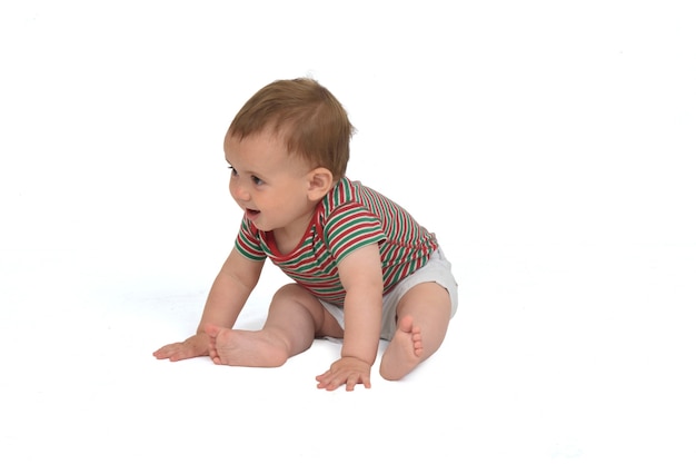 10 month old baby sitting on the floor  on white background