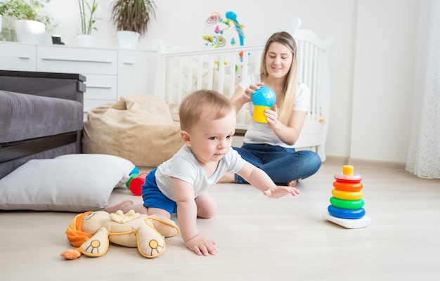 カラフルなおもちゃで床で遊ぶ生後10ヶ月の男の子