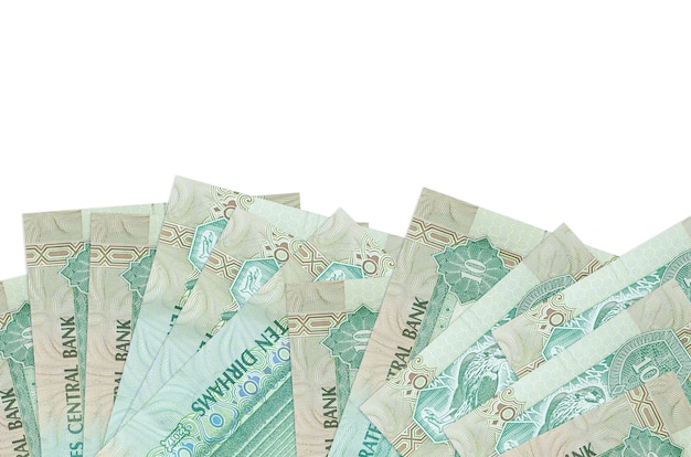 10 UAE dirhams bills lies on bottom side of screen isolated on white wall with copy space. 