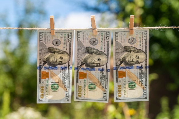 Foto 100 dollar biljet op hangende groene natuur achtergrond dollarbiljetten hangen aan een touw close up