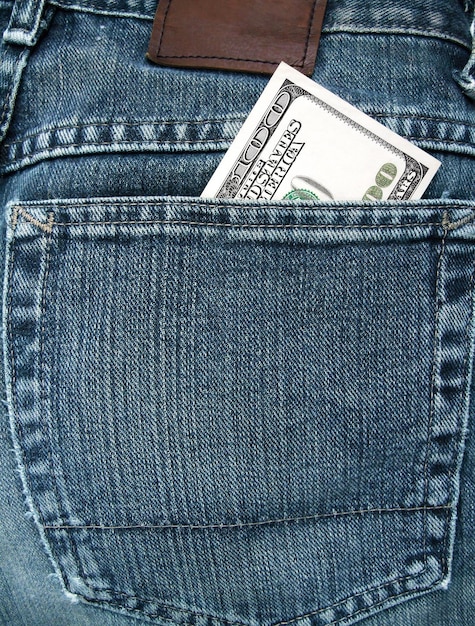 Photo a 100 dollar bill in a blue jeans pocket