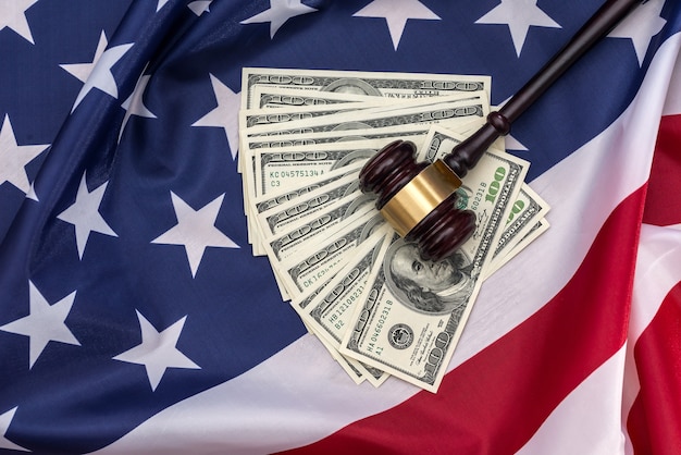 100-dollar bills and a hammer of judges placed on the American flag .