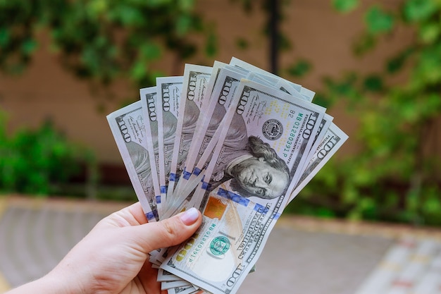 100 - dollar bills in the hands of a woman. Count or spend money.