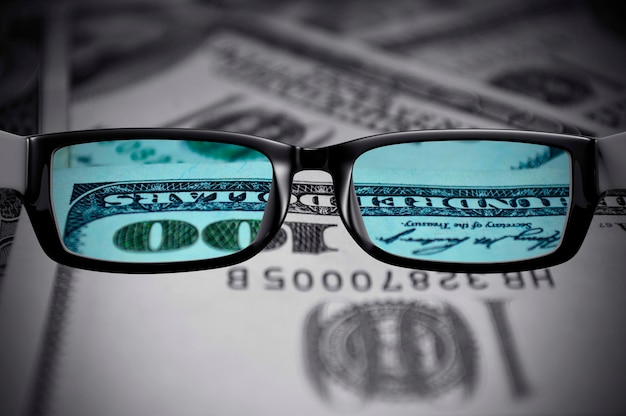 100 dollar bills view through glasses.