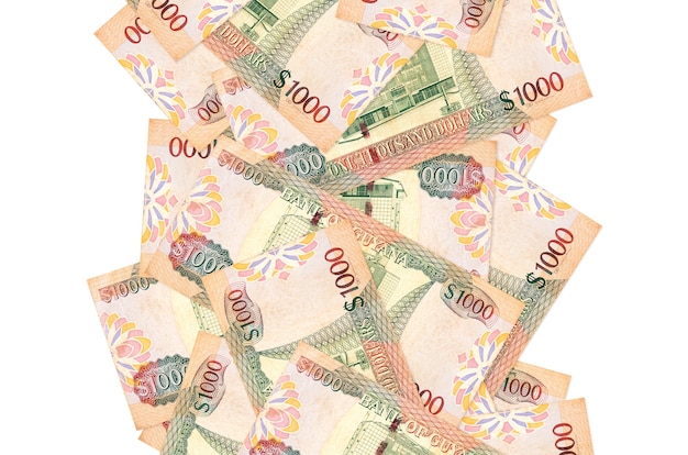 Купюры 1000 гайанских долларов, летящие вниз, изолированные на белом. Многие банкноты падают с белым пространством для копирования слева и справа