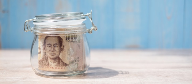 1000 Thai Baht banknote in glass jar. Money, business