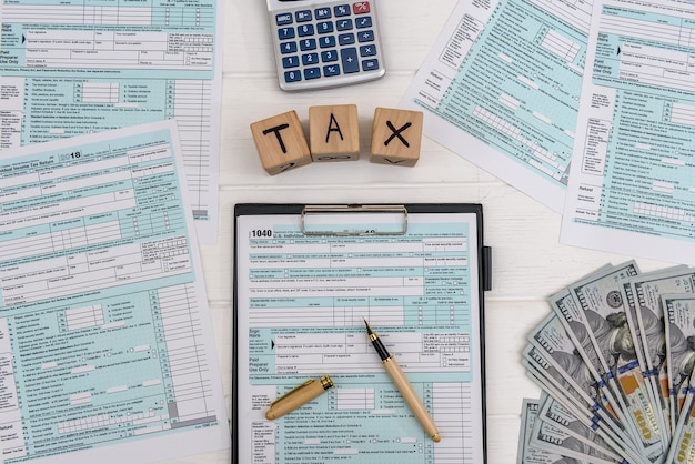 1040 tax form on clipboard with wooden cubes and calculator