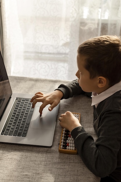 A 10yearold boy learns mental math with a laptop and abacus