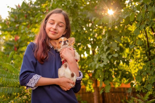 흰색 치와와 강아지를 안고 있는 10세 소녀 소유자와 애완 동물