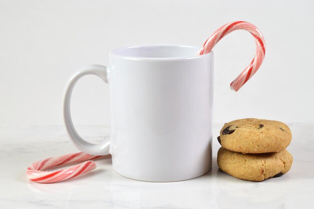 Photo 11 ounce christmas coffee mug mockup with cookies and candy canes