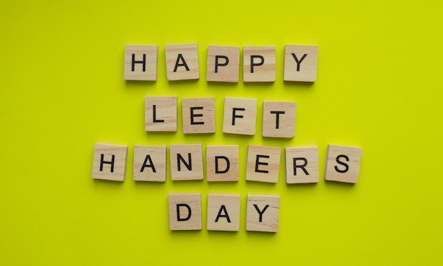 13 augustus: Internationale Dag van de Linkshandigen: Een minimalistisch spandoek met de inscriptie in houten letters op een gele achtergrond.