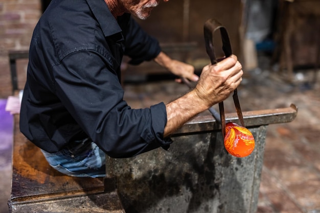 13 september 2022 Murano Italië Glasblazer aan het werk in werkplaats in Murano Italië die handgemaakt glaswerk maakt