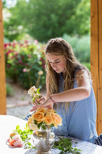 正式な庭からバラをアレンジする 13 歳の少女