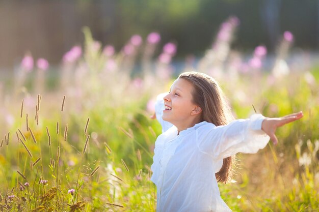 사진 열세 살 소녀는 여름에 꽃이 피는 에 서서 깨한 공기와 자유를 즐긴다.