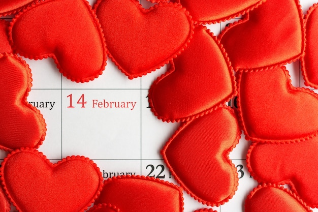 Foto 14 febbraio san valentino. cuori rossi di stoffa sul calendario