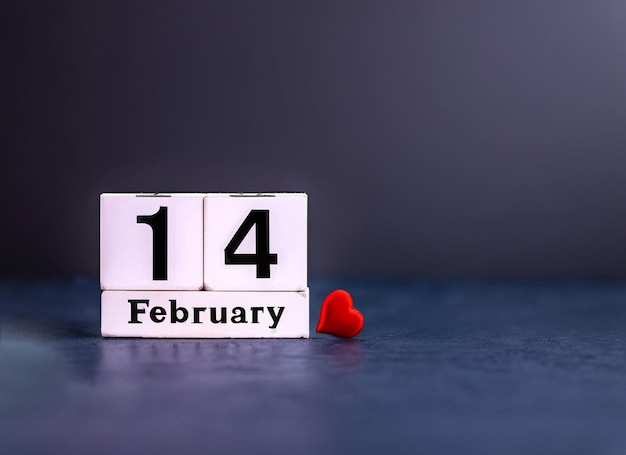 14 februari kalender met papieren hart op een donkere houten achtergrond met kopieerruimte