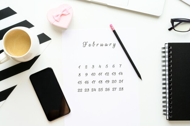 14 February calendar on work space with pink gift heart Valentine's Day card, cup of cofe, Flatlay