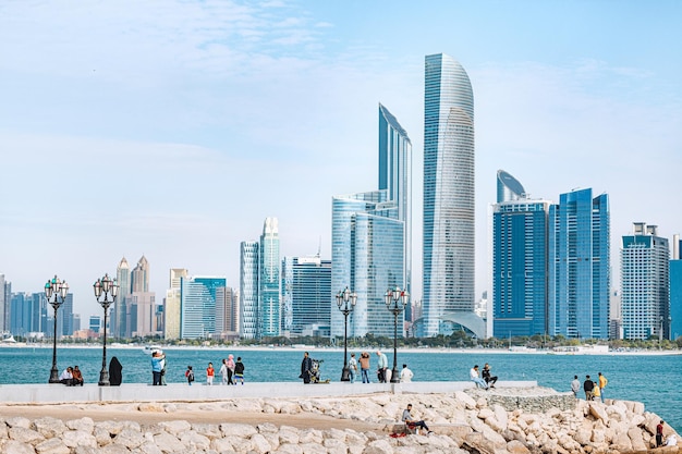 15 January 2023 Abu Dhabi UAE panoramic view of Abu Dhabi's skyscrapers and people resting at coast