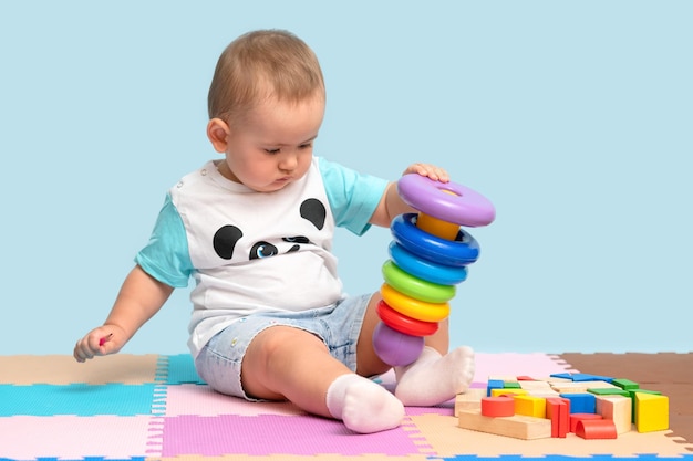 A 1523monthold baby sitting playing with a pyramid bath made of colorful plastic rings