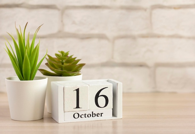 16 oktoberop een houten kalender op een tafel of plankEen dag van de herfstmaandKalender voor oktober Herfst