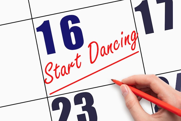 16e dag van de maand Handgeschreven tekst START DANCING en een lijn trekken op kalenderdatum