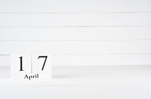 17 april, dag 17 van de maand, verjaardag, verjaardag, houten blokkalender op witte houten achtergrond met exemplaarruimte voor tekst.