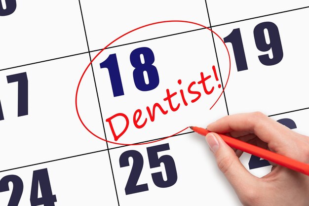 18th day of the month Hand writing text DENTIST and circling the calendar date