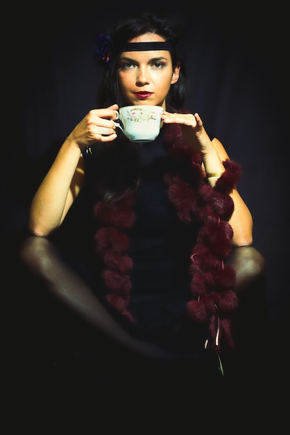 1920s style woman drinks from the cup