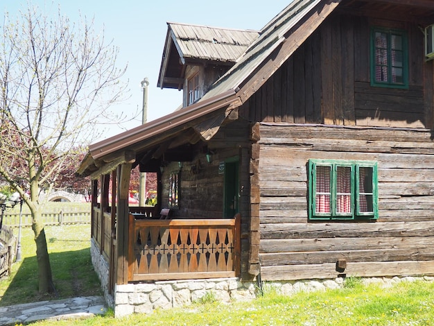 19th century Bosnian mountain traditional dwelling Restored ethno building Wooden deck kitchen checkered curtains