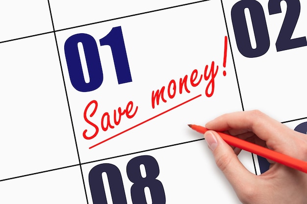 月の 1 日 手書きのテキスト SAVE MONEY とカレンダーの日付に線を引く