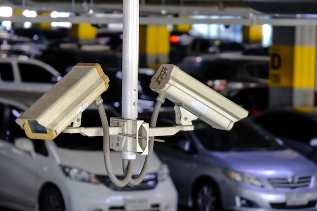 2 CCTV or Close Circuit Television are monitor and record cars in parking lot of shopping mall