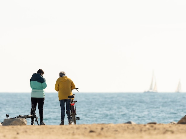 ビーチで自転車を持つ 2 人の女の子