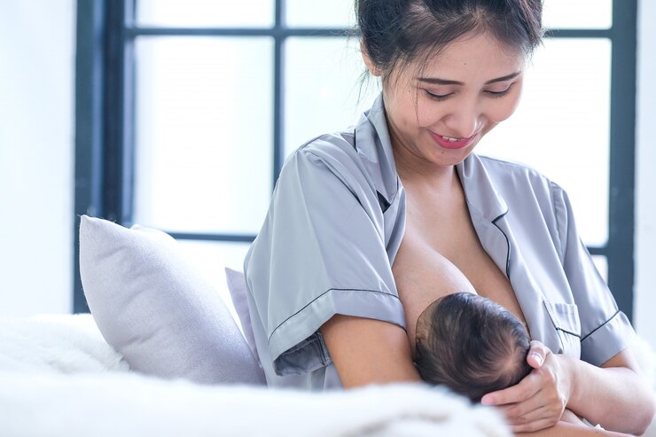Photo 生後2ヶ月のアジアの赤ちゃんは母乳を吸って幸せです。