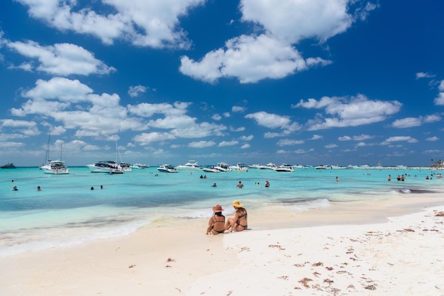 2 sexy meisjes dames zitten in Braziliaanse string bikini op een wit zandstrand turquoise Caribische zee Isla Mujeres eiland Caribische Zee Cancun Yucatan Mexico