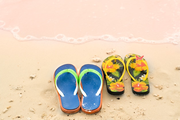 2 slippers op het witte zandstrand, reis- en vakantietijd