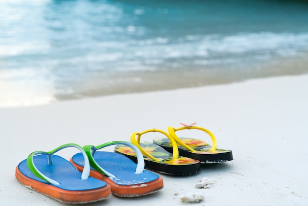 2 slippers op het witte zandstrand, reis- en vakantietijd