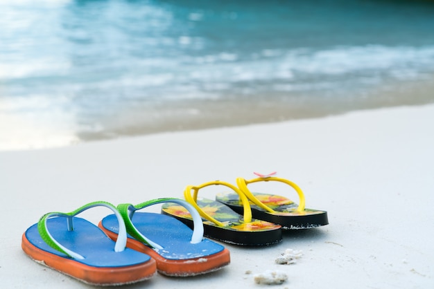 2 pantofole sulla spiaggia di sabbia bianca, viaggio e tempo di vacanza