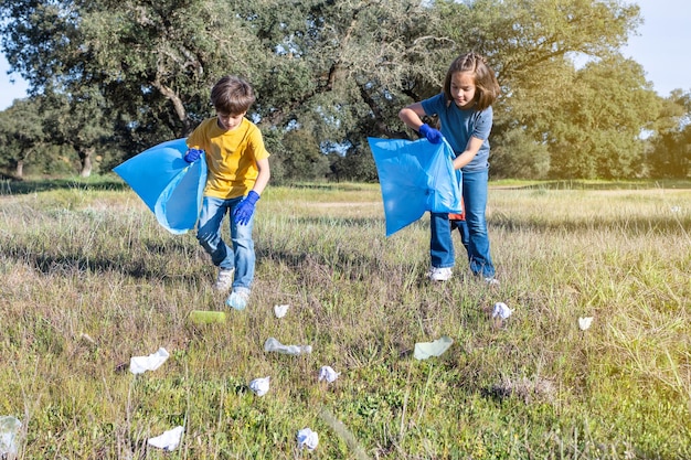 自然を大切にする森でプラスチックを集める 2 人のボランティアの子供たち