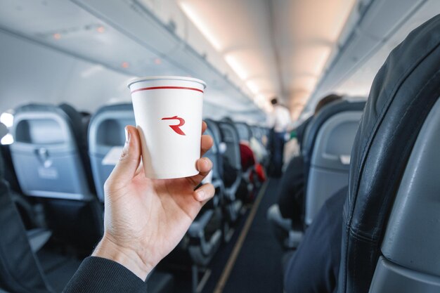 20 February 2021 Ufa Russia paper cup with Rossiya airline logo in the interior of an airplane during flight