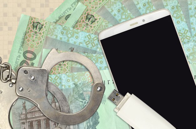 20 Ukrainian hryvnias bills and smartphone with police handcuffs