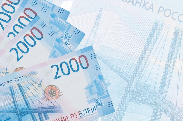 2000 russian rubles bills lies in stack on wall of big semi-transparent banknote.